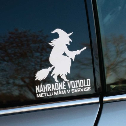 Plotrovaná nálepka na auto so siluetou čarodejnice na metle a vtipným textom „Náhradné vozidlo, metlu mám v servise“.
