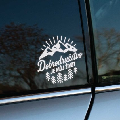 Plotrovaná nálepka na auto s motívom hôr, stromov a nápisom „Dobrodružstvo je môj život“ v outdoor dizajne.