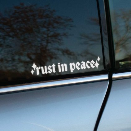 Plotrovaná nálepka na auto s gotickým nápisom „rust in peace“ doplneným o ozdobné hviezdičky na oboch stranách.