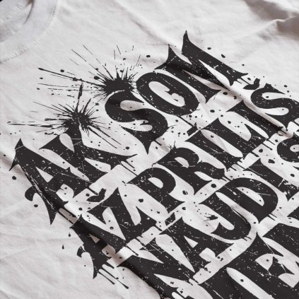 Potlač na tričku s čiernym nápisom „Ak som až príliš, nájdi si menej“ v štýle graffiti so špliechancami. Biele tričko s potlačou.