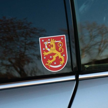 Tlačená nálepka na auto so štátnym znakom Fínska, zlatý lev s mečom na červenom štíte posiatom bielymi ružami.
