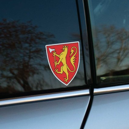 Tlačená nálepka na auto so štátnym znakom Nórska, zlatý lev s korunou držiaci sekeru na červenom štíte.