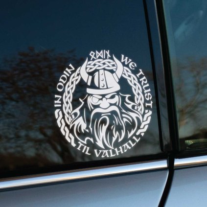 Plotrovaná nálepka na auto s tvárou vikinga v prilbe, runovým kruhom a nápisom „In Odin We Trust, Til Valhall“.