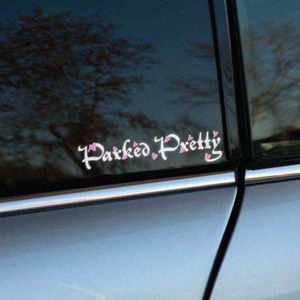 Plotrovaná nálepka s ozdobným nápisom Parked Pretty v bielom písme, doplneným malými ružovými srdiečkami okolo písmen.