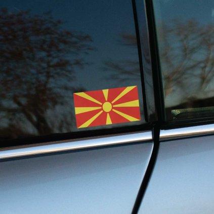 Tlačená nálepka vlajka Severného Macedónska s motívom žltého slnka na červenom podklade, vhodná ako nálepka na auto alebo kufor.