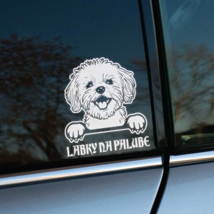 Plotrovaná nálepka maltezáka s veselým výrazom a nápisom „LABKY NA PALUBE“, detailne spracovaný chlpatý motív malého psa.