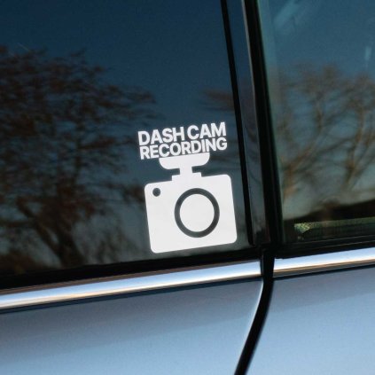 Plotrovaná nálepka s ikonou kamery a textom DASH CAM RECORDING, jednoduchý vyrezaný dizajn so zreteľným upozornením v technickom štýle.