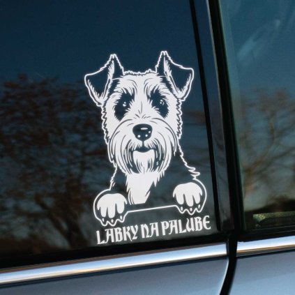 Plotrovaná nálepka **Airedale teriér** s textom **"Labky na palube"** - čierno-biely psík, ktorý sa pozerá spoza okna, vhodná na hladké povrchy.