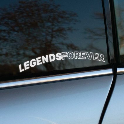 Plotrovaná biela nálepka na bočnom okne auta s mierne zahnutým nápisom LEGENDS FOREVER. Písmo je tučné a má orezanú siluetu.
