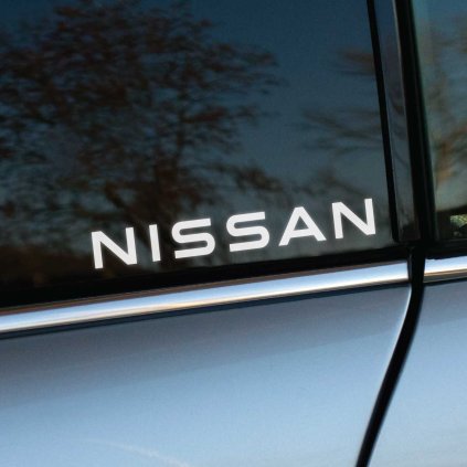 Plotrovaná nálepka NISSAN, vyrezávaný text s čistým bezpätkovým písmom, minimalistický dizajn s horizontálnym usporiadaním.