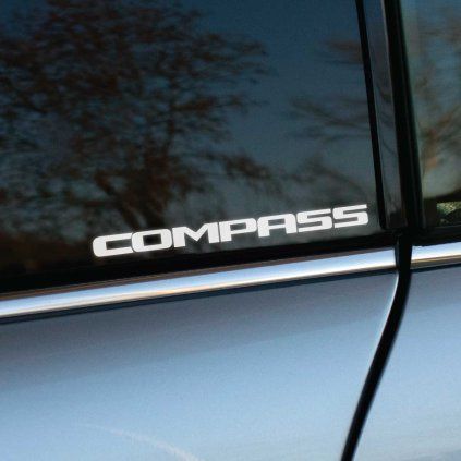 Plotrovaná nálepka s textom COMPASS v hrubých technických písmenách, model vozidla Jeep.