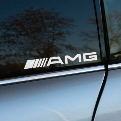 Elegantná biela nálepka s logom AMG na bočnom okne luxusného Mercedes-Benz. Táto nálepka vyniká na tmavom pozadí okna a dodáva autu športový a exkluzívny vzhľad. Ideálna voľba pre tých, ktorí chcú zvýrazniť výkon a prestíž svojho vozidla pomocou kvalitnej auto nálepky.