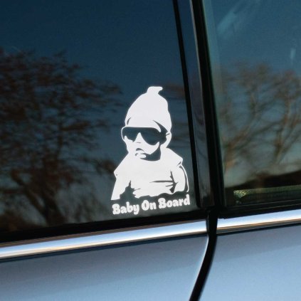 Plotrovaná nálepka s ilustráciou bábätka v slnečných okuliaroch a čiapke. Pod postavou sa nachádza nápis Baby On Board v oblom a tučnom type písma.