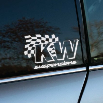 Nálepka „KW suspensions“ s dynamickým šachovnicovým vzorom umiestnená na zadnom bočnom okne auta. Športový dizajn s dôrazom na výkon a motoristický štýl perfektne dopĺňa vzhľad vozidla. Reflexia okolitej krajiny na skle dodáva fotografii hĺbku a zvýrazňuje kvalitu aplikácie nálepky. Skvelá voľba pre fanúšikov automobilových úprav a značky KW.