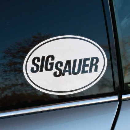 Nálepka s logom „SIG SAUER“ v oválnom rámiku nalepená na zadnom bočnom okne auta. Výrazný dizajn s čistými líniami pôsobí profesionálne a elegantne, pričom dodáva vozidlu jedinečný charakter. Odraz okolia na skle vytvára zaujímavý vizuálny kontrast, ktorý zvýrazňuje precízne spracovanie nálepky. Skvelý doplnok na personalizáciu auta alebo podporu značky.