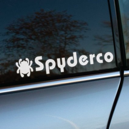 Nálepka s logom a nápisom „Spyderco“ umiestnená na zadnom bočnom okne auta. Charakteristická grafika s pavúkom dodáva nálepke originálny a výrazný vzhľad. Lesklé sklo s jemným odrazom okolitej krajiny umocňuje elegantný dojem. Ideálna voľba na personalizáciu vozidla alebo vyjadrenie záľuby v značke pomocou kvalitnej samolepky na auto.