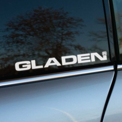 Biela nálepka „GLADEN“ s moderným a čistým dizajnom nalepená na tmavom bočnom okne auta. Logo značky GLADEN, známej svojimi špičkovými audio systémami, vyniká na tmavom pozadí a pôsobí profesionálne a štýlovo. Strieborná karoséria auta dopĺňa sofistikovaný vzhľad, pričom nálepka vyjadruje záväzok k vysokému výkonu a kvalite zvuku. Ideálne pre audio nadšencov a motoristov, ktorí chcú zdôrazniť svoju vášeň pre dokonalý zvuk a moderný dizajn.   Kľúčové slová: nálepka GLADEN, audio systém, tuning doplnky, nálepky na auto, štýlové auto doplnky, personalizácia vozidla.