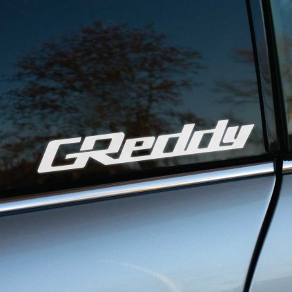 Biela nálepka „GReddy“ s dynamickým a športovým písmom nalepená na tmavom bočnom okne auta. Tento dizajn vyjadruje výkon a kvalitu, ktoré značka GReddy prináša do sveta tuningových a vysokovýkonných automobilových dielov. Ostré línie loga vynikajú na tmavom skle, pričom strieborná karoséria vozidla pridáva na sofistikovanosti a športovom vzhľade. Ideálne pre tuningových nadšencov a fanúšikov, ktorí chcú zvýrazniť svoju vášeň pre motoršport a technické inovácie.   Kľúčové slová: nálepka GReddy, tuning doplnky, vysokovýkonné diely, nálepky na auto, športový dizajn, personalizácia vozidla.