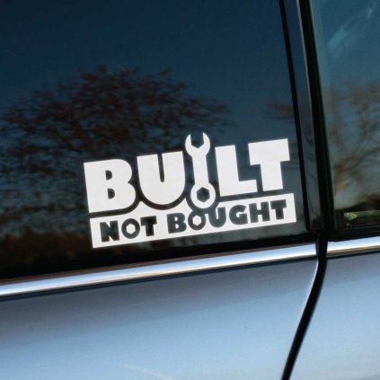 Plotrovaná nálepka s nápisom BUILT NOT BOUGHT v dvoch riadkoch, kde písmeno U dopĺňa malá ikona vidlicového kľúča.