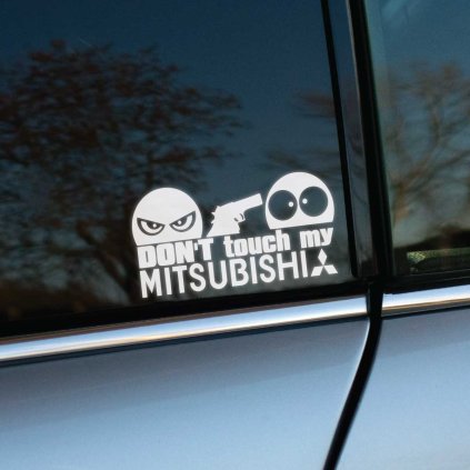 Plotrovaná nálepka s textom „Don’t touch my Mitsubishi“, zamračená tvár so zbraňou mieri na prekvapenú tvár.