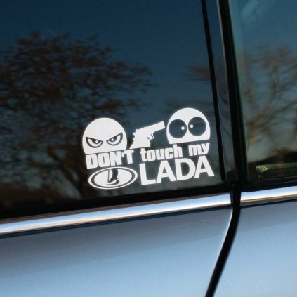 Vyrezávaná nálepka s textom „Don’t touch my Lada“, zamračená tvár drží zbraň a mieri na prekvapenú tvár.