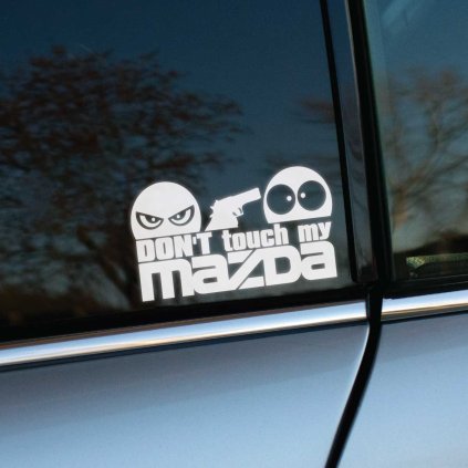 Vyrezávaná nálepka s textom „Don’t touch my Mazda“, zamračená tvár drží zbraň a mieri na prekvapenú tvár.