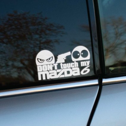 Plotrovaná nálepka s textom „Don’t touch my Mazda 6“, nahnevaná tvár mieri pištoľou na prekvapenú tvár.