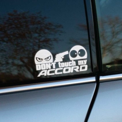 Vyrezávaná nálepka s textom „Don’t touch my Accord“, zamračená tvár drží pištoľ a mieri na udivenú tvár.