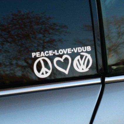 Plotrovaná nálepka s textom „PEACE·LOVE·VDUB“ a symbolmi mieru, srdca a loga Volkswagen na bočnom okne auta.