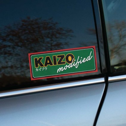 Tlačená nálepka na auto s nápisom "KAIZO modified" v retro dizajne, doplnená japonskými znakmi, ideálna pre fanúšikov tuningu a úprav áut.