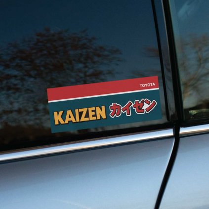 Tlačená nálepka na auto s nápisom "KAIZEN", japonskými znakmi a logom Toyota, inšpirovaná filozofiou neustáleho zlepšovania.