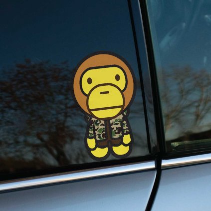 Tlačená nálepka na auto s kreslenou postavičkou opice v maskáčovej bunde, jednoduchý a hravý dizajn.