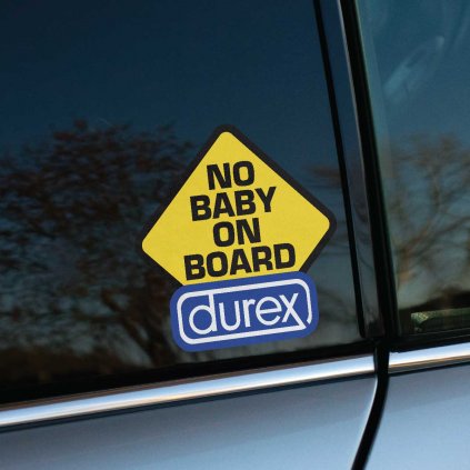 Fotografia zobrazuje vtipnú nálepku na zadnom okne auta s nápisom „No Baby on Board“ a logom značky Durex. Táto kreatívna nálepka je výrazným a humorným spôsobom, ako vyjadriť svoj postoj alebo osobnosť. Žltý dizajn v štýle dopravnej značky okamžite priťahuje pozornosť a zaručene vyčarí úsmev na tvári každého, kto ju uvidí. Ideálna voľba pre tých, ktorí majú radi originálne a zábavné nálepky na svoje auto.