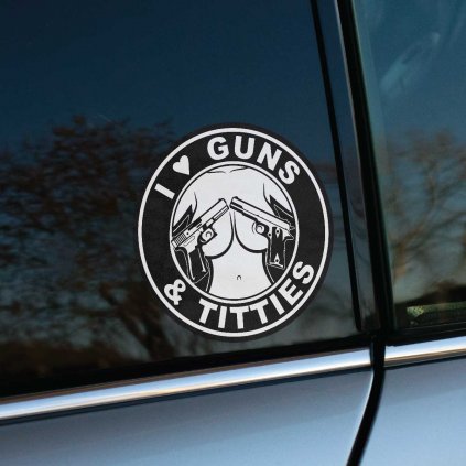 Tlačená nálepka na auto s kruhovým motívom zbraní a ženského torza, doplnená textom „I ♥ Guns & Titties“.