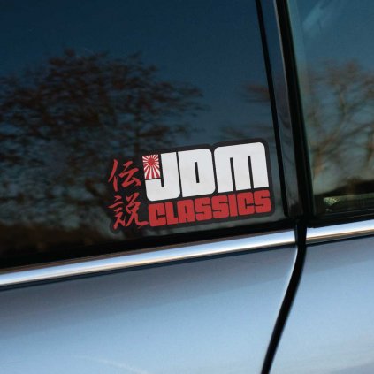 Tlačená nálepka na auto s nápisom JDM Classics, japonskými znakmi a symbolom vychádzajúceho slnka.