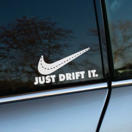 Plotrovaná nálepka na auto s nápisom „Just Drift It“ a upraveným motívom cesty v tvare známeho loga.