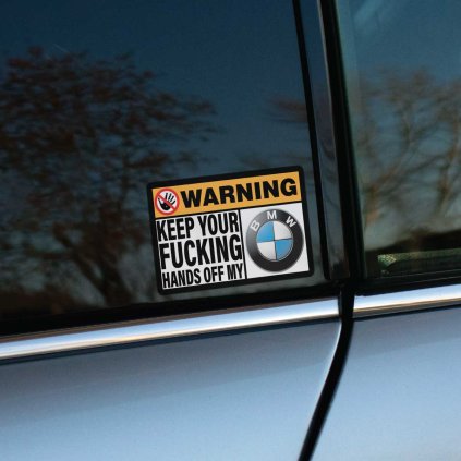 Tlačená nálepka, obdĺžnikový formát s piktogramom ruky a nápisom: WARNING KEEP YOUR FUCKING HANDS OFF MY a logo BMW.