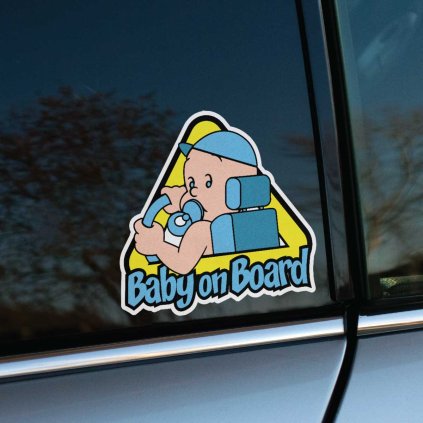 Tlačená nálepka “Baby on Board” s motívom chlapčeka v autosedačke, držiaceho volant, v hravom kreslenom štýle.