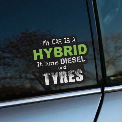 Zábavná nálepka na zadné okno auta so sloganom „My car is a hybrid. It burns diesel and tyres“ v kontraste zelených a bielych písmen. Nálepka je aplikovaná na okne strieborného vozidla, čo jej dodáva ešte väčšiu viditeľnosť. Táto auto nálepka je skvelým doplnkom pre tých, ktorí chcú vyjadriť svoj postoj k jazdeniu s úsmevom. Ideálna pre vodičov, ktorí majú radi originálne a vtipné detaily na svojom aute.