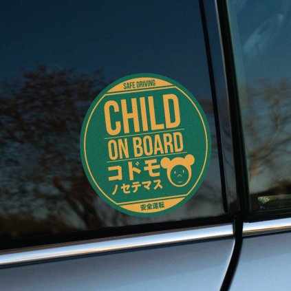 Tlačená nálepka “Child on Board” v kruhovom dizajne s textom v angličtine a japončine, doplnená jednoduchou ilustráciou medvedej hlavy.