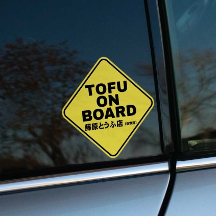Tlačená nálepka v tvare výstražnej tabuľky s textom „TOFU ON BOARD“ a japonským nápisom, inšpirovaná motívom Initial D.