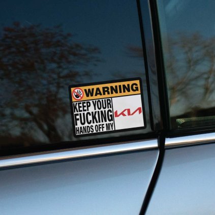 Tlačená nálepka obdĺžnikového tvaru s varovným textom „WARNING - KEEP YOUR FUCKING HANDS OFF MY KIA“ a preškrtnutým symbolom ruky.