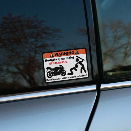 Tlačená nálepka obdĺžnikového tvaru s varovaním „Nedotýkaj sa mojej HONDA“, grafikou motocykla a hrozbou vážneho zranenia pri zásahu palicou.