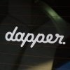 Jednoduchá a štýlová biela nálepka s nápisom "dapper." je nalepená na zadnom skle vozidla. Tento elegantný dizajn s jemným fontom vyžaruje sofistikovanosť a jemnú eleganciu, čo z nej robí ideálny doplnok pre tých, ktorí majú radi čisté línie a minimalistický štýl. Nálepka je perfektná pre vodičov, ktorí chcú svojmu autu dodať nenápadný, no pritom výrazný charakter, zdôrazňujúc svoj vyberaný vkus a záľubu v estetike.