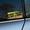 Tlačená nálepka „Street Racing Is Not a Crime“ s výrazným textom a vtipným dodatkom, ideálna pre fanúšikov pouličných závodov a tuningovej kultúry.