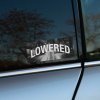 Tlačená nálepka „Lowered“ s čiernobielym mestským motívom a dynamickou typografiou, ideálna pre fanúšikov znížených áut a stance kultúry.