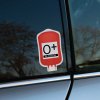 Tlačená nálepka v tvare krvného vaku s označením 0+ Rh POSITIVE, ideálna na auto, prilbu či kufor pre medicínske označenie.