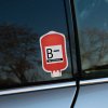 Tlačená nálepka na auto v tvare krvného vaku s textom B− Rh NEGATIVE, vhodná na zreteľné označenie krvnej skupiny.