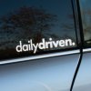 Plotrovaná nálepka „dailydriven.“ v jednoduchom modernom dizajne, určená pre každodenné projekty.