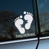 Plotrovaná nálepka dvoch detských stôp so zúbkovaným výrezom v strede a nápisom v presnom znení Baby On Board.